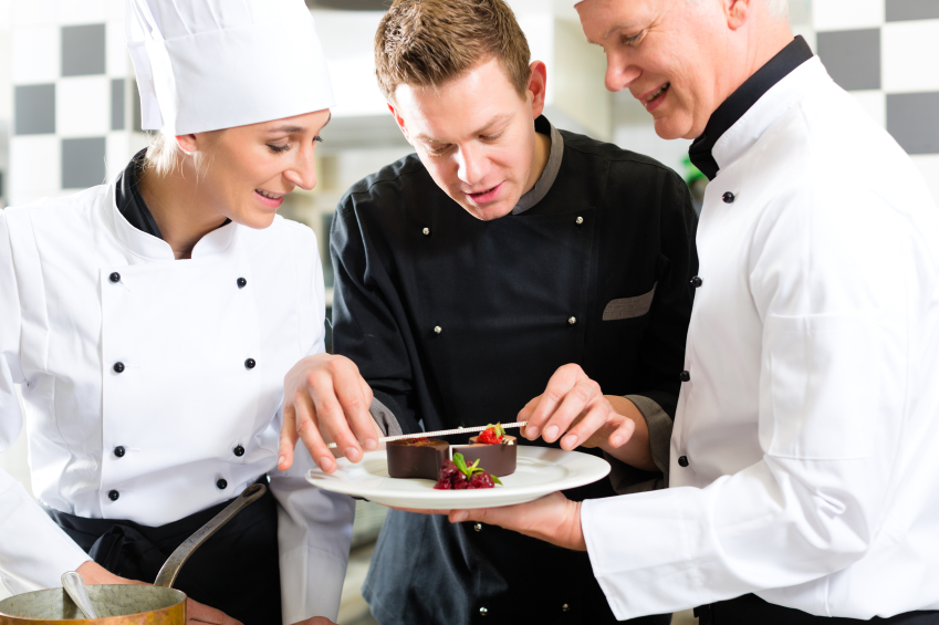 Chef team in restaurant kitchen with dessert working together